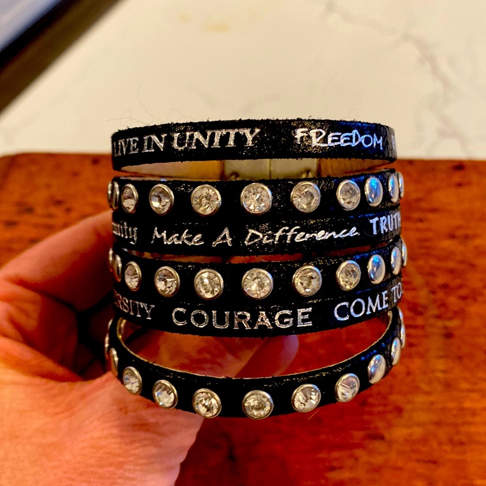 Humanity leather cuff with jewels and writing.